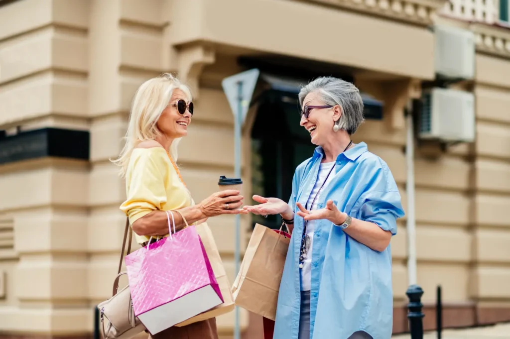 A professional carer and her elderly client share a happy moment while shopping together in a local West Sussex high street.