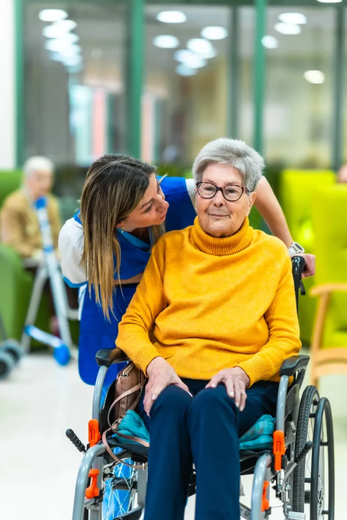 Carer assisting an elderly woman in a wheelchair, providing gentle and respectful home care support.