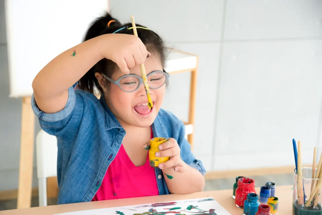 A dedicated Careline 24 carer engaging in a calming, focused sensory activity with a joyful autistic child in their familiar home environment.