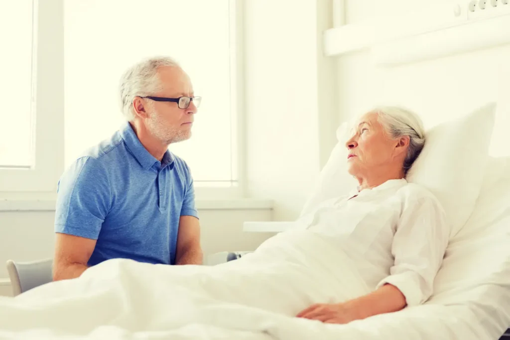 A compassionate Careline 24 nurse having a supportive, reassuring conversation with a senior couple about end-of-life care options in the comfort of their home.