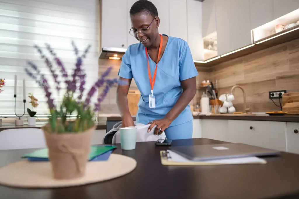 A professional carer from our consistent team carefully organizes medication for a client in their kitchen, ensuring safety and peace of mind.