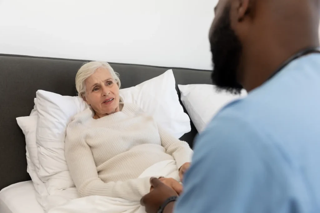 A professional Careline 24 carer providing respectful, dignified personal care support to an elderly gentleman in his own bathroom.