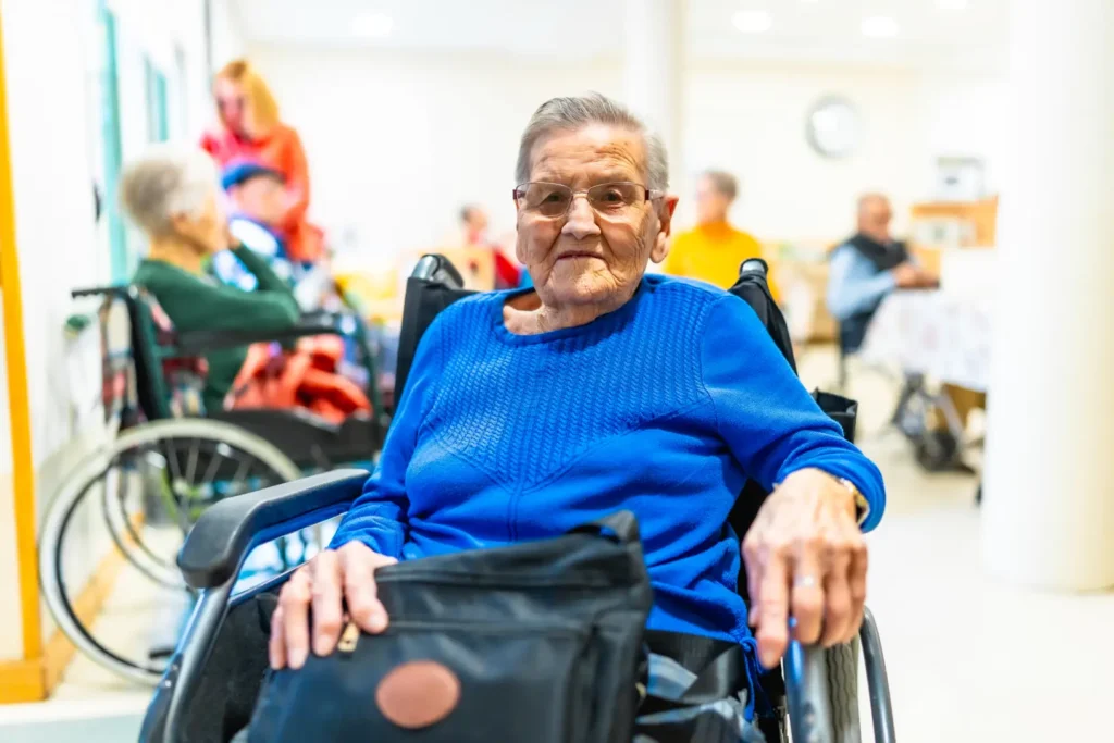 Elderly woman sitting comfortably in a wheelchair, receiving dignified care and support in a safe and welcoming environment.