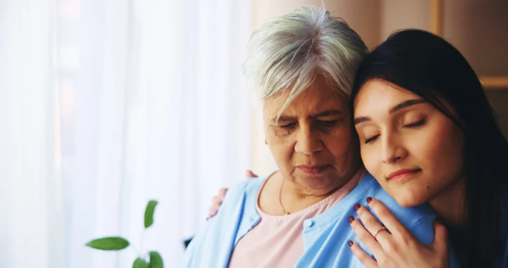 A compassionate Careline 24 mental health carer offering gentle, reassuring emotional support to an elderly woman in her own home.