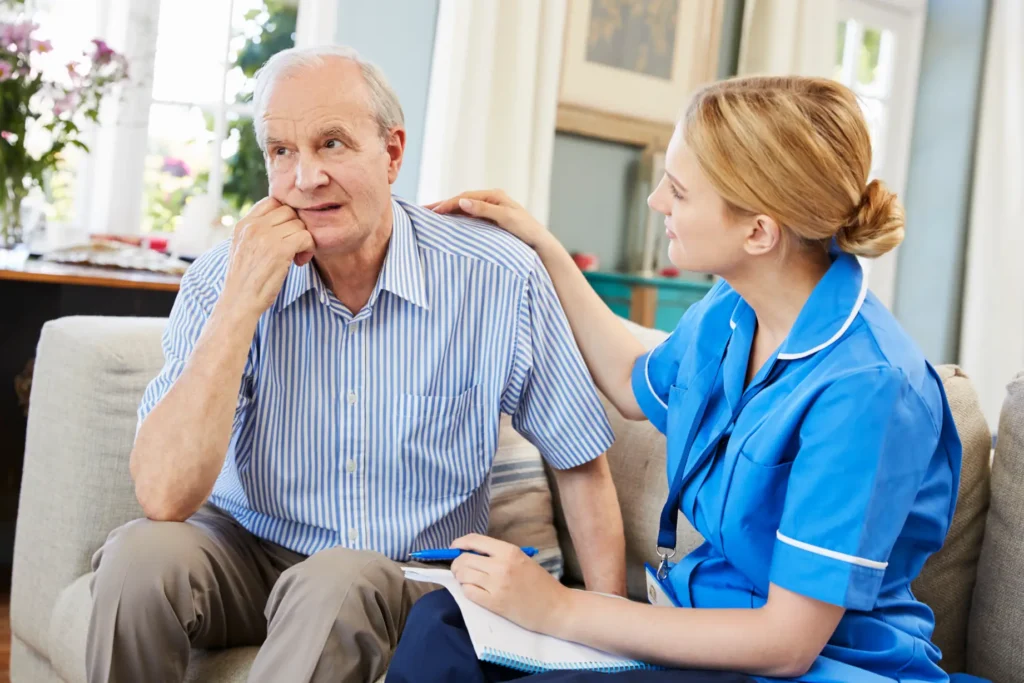A compassionate Careline 24 mental health carer having a supportive, one-to-one conversation with a senior gentleman in his own home.