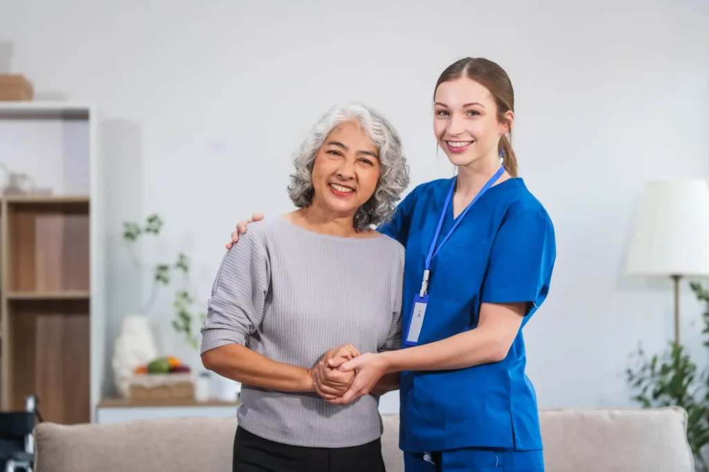A professional Careline 24 carer provides steady, supportive assistance to an elderly lady during a gentle walk in a tranquil garden, promoting safe mobility and independence.